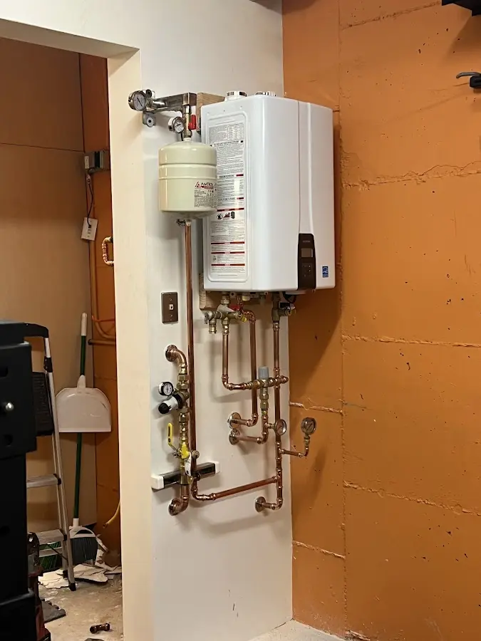 Plumbing technician inspecting water heater connections in Sugar Land